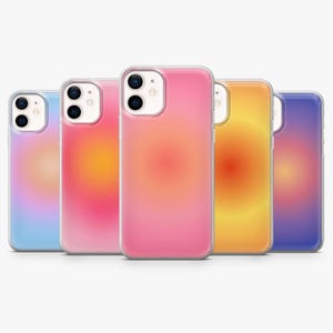 May include: Five mobile phone cases with a gradient design. The cases feature a range of colours, including pink, orange, yellow, blue, and purple. Each case has a clear border and a smooth, glossy finish. The gradient effect creates a soft, blurred appearance.