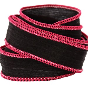 a close up of a black and pink ribbon