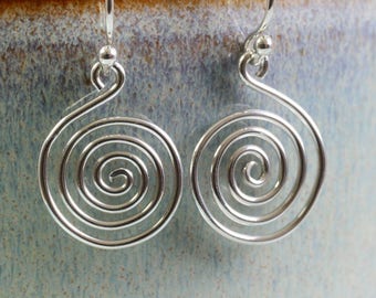 May include: Silver spiral earrings with a simple, elegant design. The earrings are made of wire and have a smooth, polished finish.