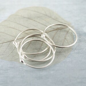 Puede incluir: Un conjunto de cinco anillos apilables de plata con un pequeño detalle de cuentas en cada anillo.