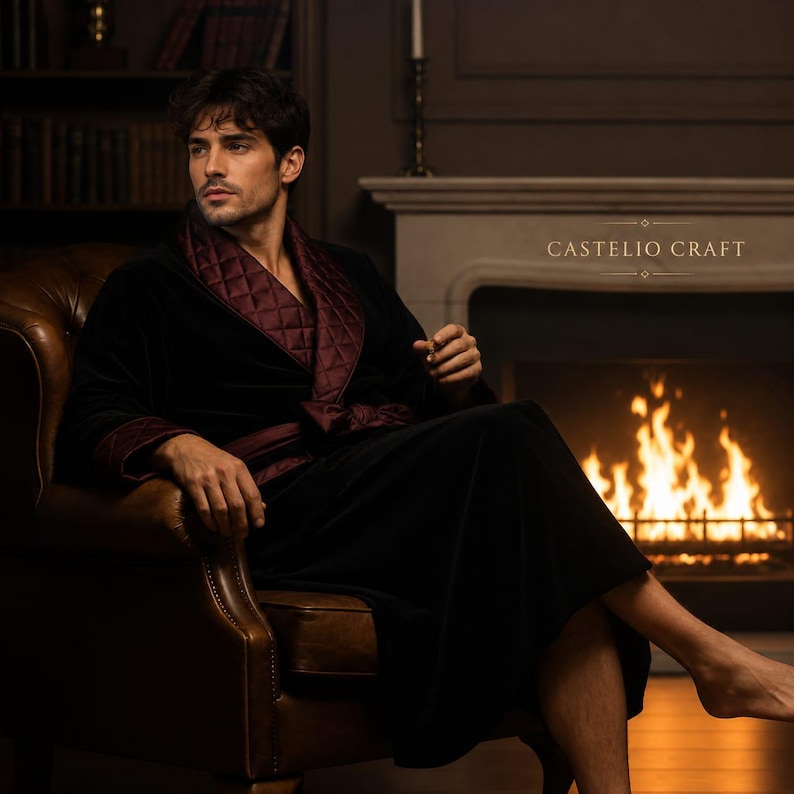 May include: A black velvet robe featuring a quilted burgundy shawl collar and matching cuffs. The garment includes a tie belt at the waist and displays the text CASTELIO CRAFT in white lettering on the right side of the chest area.