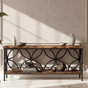 May include: A wooden console table with a black metal frame and decorative circular design. The table is adorned with decorative bowls, vases, and an owl figurine. The table is placed against a neutral wall.