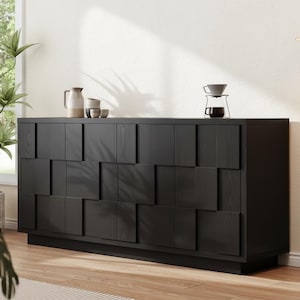 May include: A black wooden sideboard with a geometric design on the front. The sideboard has a rectangular shape and sits on a low base. Decorative items, including a coffee maker, are on top. A large plant is in the background.
