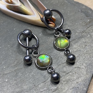 May include: Two silver body jewelry pieces with dangling opal-like stones. Each piece has a circular ring with a small ball on one side and a dangling stone on the other. The stones are iridescent green and yellow.