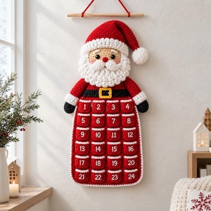 May include: A crocheted Santa Claus wall hanging advent calendar featuring a red hat, white beard, and a black belt with a yellow buckle. The body includes twenty-four small red pockets, each embroidered with a white number from one to twenty-four.
