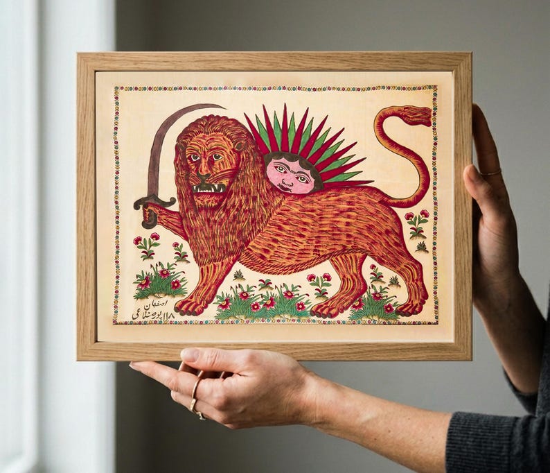 May include: A framed rectangular print featuring a stylized illustration of a lion holding a curved sword. The lion has a sun face on its back with green rays. The artwork includes small floral motifs, a decorative border, and Persian script.