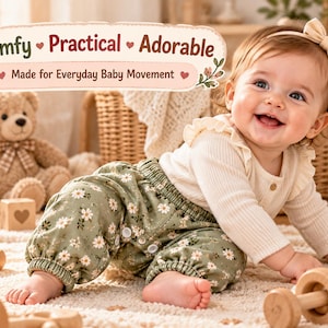 May include: A baby wearing a cream-coloured long-sleeve ribbed shirt with ruffled shoulders and olive green trousers featuring a white daisy floral pattern. The image includes text that reads: Comfy, Practical, Adorable, Made for Everyday Baby Movement.