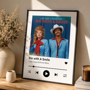 Könnte beinhalten: Gerahmtes Poster mit dem Text "Die with a Smile" mit Lady Gaga und Bruno Mars. Das Bild zeigt die Künstler in passenden blauen Outfits. Darunter befindet sich eine Musikplayer-Oberfläche mit Wiedergabe-, Überspringen- und Wiederholungssymbolen.