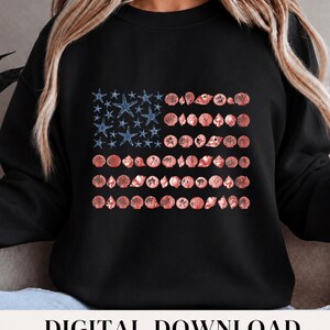 May include: A black crewneck sweatshirt featuring a graphic design of the American flag composed of blue starfish in the canton and rows of various pink and coral-toned seashells forming the stripes across the center of the chest.