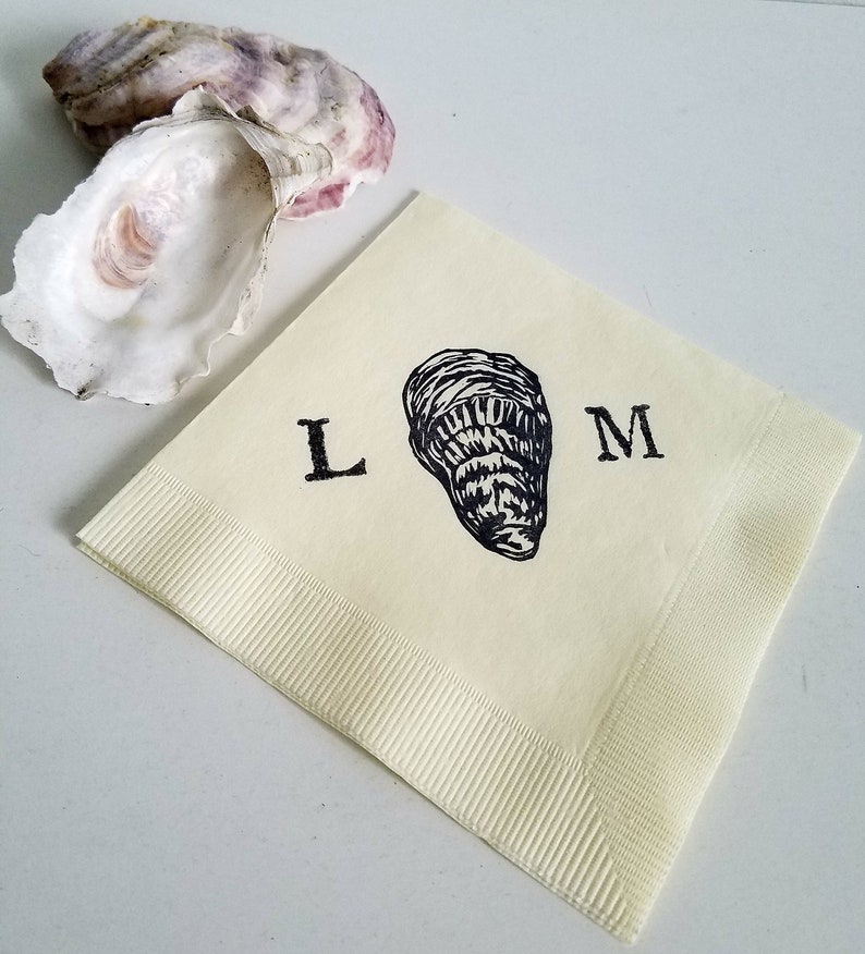 May include: A cream-colored paper napkin with a black oyster illustration and the letters "L" and "M". An open oyster shell with purple and white hues is in the background. The napkin has a ribbed border.