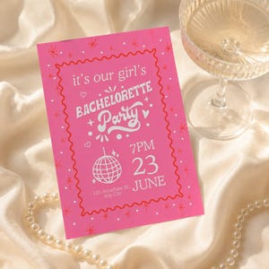 May include: A pink bachelorette party invitation with white text and a red border. The invitation includes the text "it's our girl's BACHELORETTE Party" and event details. A glass of champagne and a pearl necklace are also in the image.