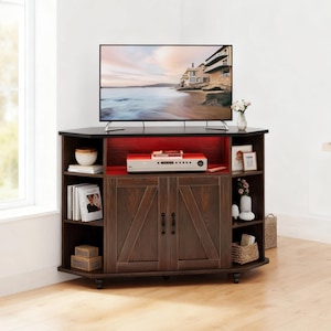 May include: A dark brown wooden corner TV stand with a flat top surface, two central cabinet doors featuring a diagonal cross-brace design, and open side shelving units. The interior shelf is illuminated with red lighting, and the unit sits on wheels.