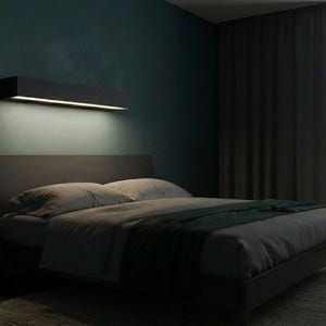May include: A bedroom featuring a dark gray bed frame with a matching headboard, topped with gray bedding and a dark green throw blanket. A rectangular wall-mounted light fixture emits a warm glow above the bed against a dark teal wall.
