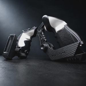 Könnte beinhalten: Ein schwarzer und silberner Phantom-Kamerastabilisator mit einem Akzent aus Kohlefaser. Das Gerät hat ein Pistolengriff-Design und befindet sich vor einem dunklen Hintergrund. Das Wort "Phantom" ist auf dem Gerät aufgedruckt.