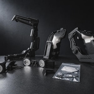 May include: A selection of black and grey VR headset accessories, including a support arm, hand grips, and various mounting components. The items are arranged on a dark surface, with a small bag of screws visible.
