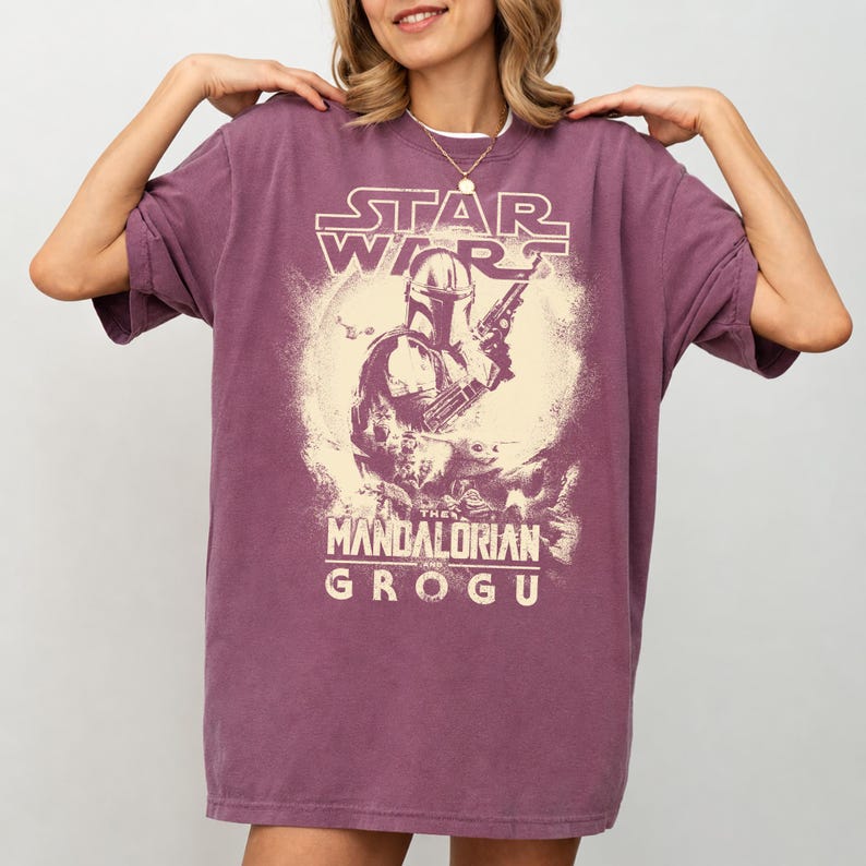Puede incluir: Camiseta de color malva con un dise&ntilde;o de Star Wars. El dise&ntilde;o incluye el logotipo de Star Wars, una ilustraci&oacute;n de The Mandalorian y Grogu. La camiseta tiene mangas cortas y un corte holgado.