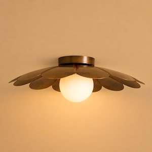 May include: A flush mount ceiling light fixture featuring a central spherical white glass bulb surrounded by a series of overlapping, petal-shaped metal plates in a dark bronze finish, with the text CRAFTSLIGHTS visible on the center.