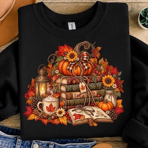 Peut inclure: Un sweat-shirt noir à col rond orné d'une impression graphique représentant une pile de livres anciens surmontée d'une citrouille, d'un nœud à carreaux, d'une lanterne, d'une tasse à feuille d'érable, d'un livre ouvert et de feuillage d'automne.