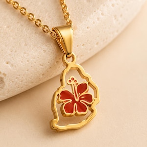 Puede incluir: Un collar de tono dorado con un colgante en forma de la isla de Sri Lanka. El colgante tiene un borde de oro pulido y contiene una incrustación de esmalte de flor de hibisco de color rojo vibrante en el centro, suspendido de una cadena dorada.