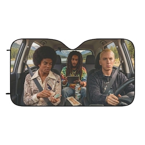 May include: A rectangular car sunshade featuring a printed interior view of a vehicle with three individuals sitting in the front and back seats. The scene depicts a person with an afro, a person with dreadlocks, and a person with short blonde hair.