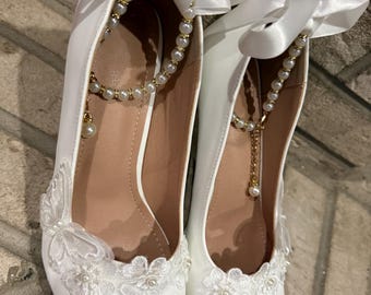 Zapatos de tacón alto blancos perlados con flores y mariposas para novias