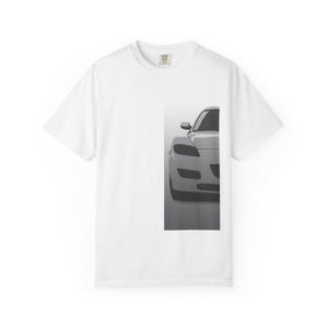 Op de afbeelding: Wit t-shirt met een grijswaardenafbeelding van een sportwagen. De voorkant van de auto is afgebeeld, met koplampen, een zijspiegel en de motorkap. Het shirt heeft een ronde hals en korte mouwen, geschikt voor casual wear.