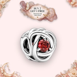 May include: A silver charm bead featuring an intricate, swirling knot design with a single round, faceted red gemstone set in the centre. Above the bead, text reads: BUY 2 GET 1 FREE MESSAGE FOR FREE PICKS, surrounded by a decorative pink cloud graphic.
