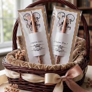 May include: Two wooden pencils in clear plastic sleeves, each attached to a card featuring a mouse-ear silhouette, the text Birthday Girl or Birthday Boy, and personalized names Emma and Liam with dates 14 June 2026 and 18 June 2026.
