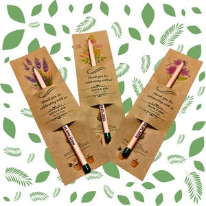 May include: Three kraft paper seed packet favors with pencils. Each packet has a floral design and the text "Thank you for celebrating with us" and the names Olivia & Jack with a date. One pencil reads "Let love Grow".