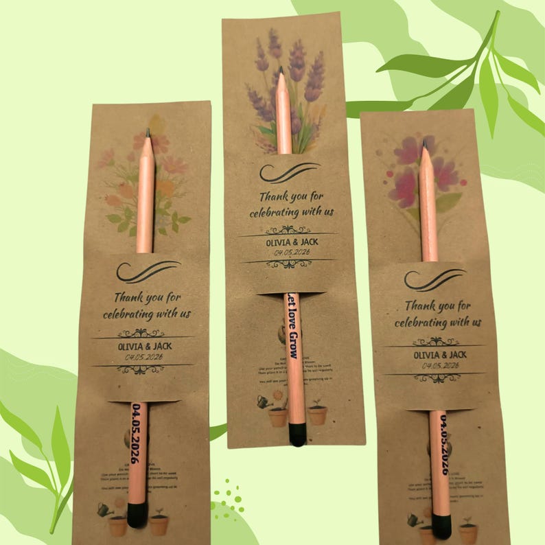 May include: Three kraft paper seed packet favors with floral illustrations and peach-colored pencils. Each packet reads "Thank you for celebrating with us" and "OLIVIA & JACK 04.05.2026". One pencil reads "Let love Grow".