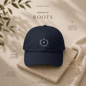 Puede incluir: Una gorra de béisbol azul marino con texto bordado en blanco dispuesto en círculo que dice MADE IN VENEZUELA, con un pequeño icono de corazón en el centro. La gorra presenta una corona estructurada y una visera curva de diseño sencillo.