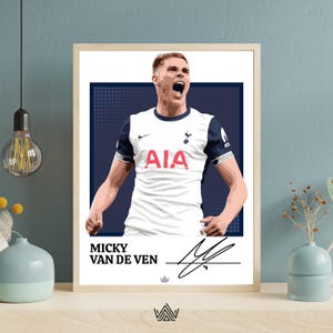 Op de afbeelding: Een ingelijste kunstdruk met een gestileerde illustratie van Micky van de Ven in een wit en marineblauw voetbalshirt. De print bevat de naam van de speler, zijn handtekening en het teamlogo. Het kunstwerk staat tegen een marineblauwe achtergrond.