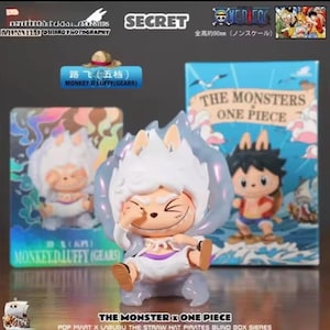 Op de afbeelding: Een verzamelobject van Monkey D. Luffy in zijn Gear 5-vorm, uit de "One Piece"-serie. De figuur is wit, oranje en paars, met een glimlachende uitdrukking. De figuur is ongeveer 9 cm hoog. De doos achter de figuur leest "The Monsters One Piece".