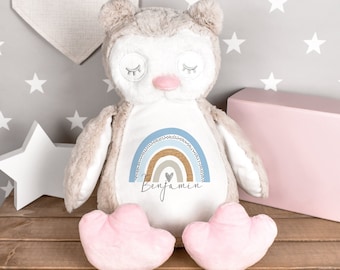 May include: A plush owl toy with a rainbow design and the name "Benjamin" embroidered on the front. The owl has pink feet and closed eyes.