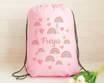 May include: Pink drawstring bag with a rainbow and heart design. The bag has the name "Freya" printed on it.