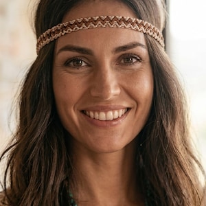 May include: A woven headband featuring a repeating chevron pattern in shades of brown and cream. The band is constructed from thin cord, displaying a textured, interlaced design that sits horizontally across the forehead with a consistent width.