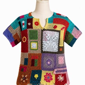 Könnte beinhalten: Ein farbenfrohes Patchwork-Häkeloberteil mit V-Ausschnitt. Das Oberteil besteht aus einer Vielzahl von quadratischen und rechteckigen Flicken in Rot-, Blau-, Grün-, Gelb- und Lilatönen. Florale und geometrische Muster sind eingearbeitet. Die Ärmel sind kurz.