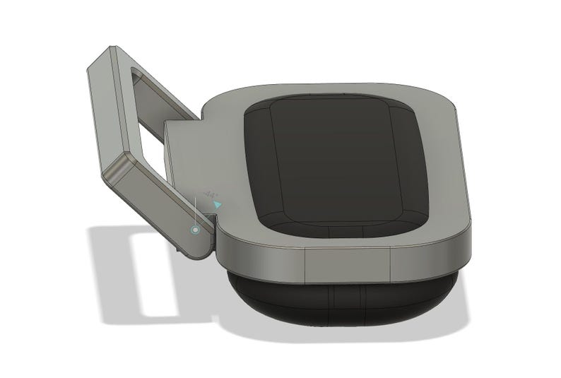 Puede incluir: Un dispositivo gris y negro con una parte superior rectangular y una base curva. El dispositivo tiene un brazo articulado en el lado izquierdo. La superficie superior es negra y los bordes son grises.