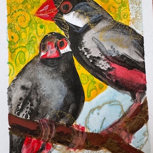 Puede incluir: Pintura a la acuarela de dos pájaros posados en una rama. Las aves tienen plumas negras y grises con picos y acentos rojos. El fondo presenta tonos amarillos y azules con adornos dorados, creando una composición vibrante y artística.