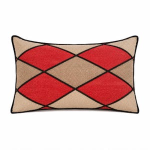 May include: A rectangular throw pillow featuring a geometric argyle pattern in red and beige. The design is defined by bold black lines that form diamond shapes across the textured surface, finished with a black piped edge around the perimeter.