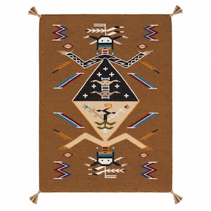 Peut inclure: Un tapis tissé rectangulaire à fond marron présentant un motif central en forme de losange avec des figures stylisées en noir, blanc, bleu et beige. Le design comprend des motifs géométriques, des petites croix et des pompons aux quatre coins.