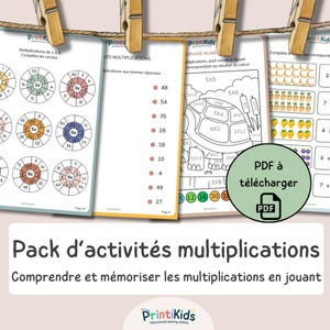 May include: A collection of educational multiplication activity sheets featuring circular math puzzles, a turtle coloring page with multiplication problems, and counting exercises with fruit illustrations, all hanging from a string with wooden clips.
