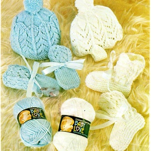 May include: Two skeins of yarn, one blue and one white, with the label "Lister/Lees Baby Love Double Knitted" on each.  A blue knitted baby hat with a white pom-pom, a pair of blue knitted baby mittens, and a pair of white knitted baby booties.