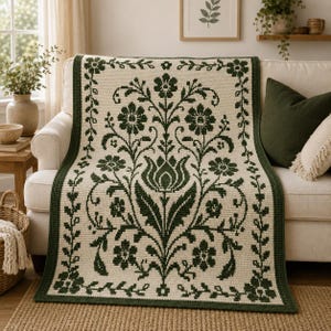 May include: A rectangular crochet blanket featuring a cream-colored base with a dark green floral pattern. The design includes a central large tulip motif surrounded by smaller flowers and leaves, all framed by a dark green border with a vine pattern.
