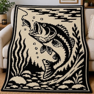 May include: A rectangular crochet blanket featuring a high-contrast black and cream graphic design. The pattern depicts a large fish jumping out of the water toward a fishing lure, surrounded by aquatic plants, bubbles, and rocky textures.