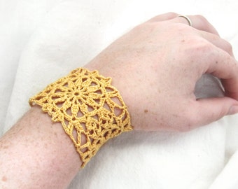 May include: A yellow crocheted bracelet with a delicate floral design.