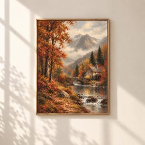 Könnte beinhalten: Ein gerahmtes Landschaftsgemälde, das eine herbstliche Szene mit leuchtend orangefarbenen und roten Bäumen, einer Steinbrücke über einen Fluss, einem rustikalen Haus im Laub und schneebedeckten Bergen im Hintergrund zeigt.