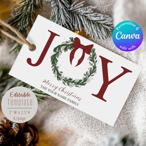 May include: A white gift tag with the word "JOY" in burgundy letters and a green wreath with a burgundy bow. The tag reads "Merry Christmas" and "THE YOUR NAME FAMILY". The tag is 3" wide and 2.5" high.