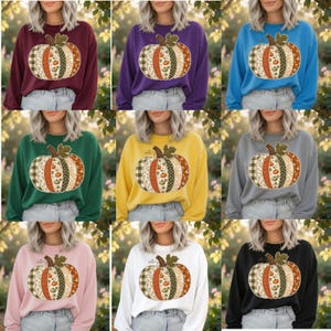 Peut inclure: Une collection de neuf sweat-shirts à col rond et manches longues dans diverses couleurs unies, chacun arborant un grand motif central de citrouille composé de panneaux verticaux aux motifs variés, incluant des carreaux, des fleurs et des pois.