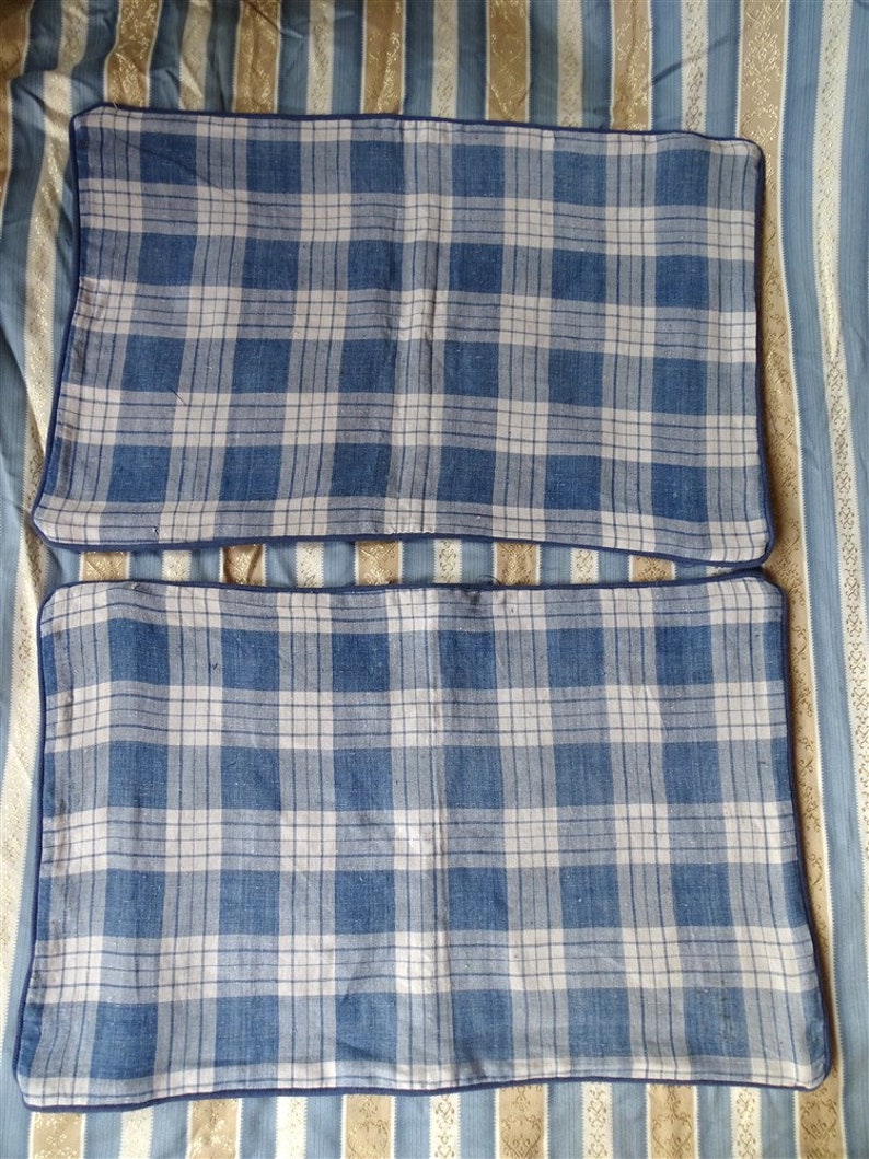 May include: Two blue and white plaid pillowcases with a dark blue border.